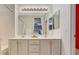Bright bathroom features a dual sink vanity with a large mirror and a tub with white tiling at 8856 Timber Mesa St, Las Vegas, NV 89139