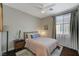 Light filled bedroom with hardwood floors, ceiling fan, modern lamp, and light colored walls at 8856 Timber Mesa St, Las Vegas, NV 89139