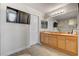 Modern bathroom featuring double sinks, a large mirror, and wood tile flooring at 9413 Ironsend St, Las Vegas, NV 89143