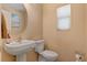 Well-lit half-bathroom with modern sink, toilet, and neutral tones at 9413 Ironsend St, Las Vegas, NV 89143