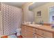 Bathroom features a sink with wooden cabinets and tub with a shower curtain at 9413 Ironsend St, Las Vegas, NV 89143
