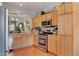This functional kitchen has wood cabinets, stainless appliances, and wood flooring at 9413 Ironsend St, Las Vegas, NV 89143