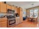 Bright kitchen features stainless steel appliances, wood cabinets, and a dining area with natural light at 9413 Ironsend St, Las Vegas, NV 89143