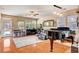 Open living room with a piano, large windows, and access to outdoor pool area at 9413 Ironsend St, Las Vegas, NV 89143