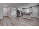 Modern kitchen features white cabinets, stainless steel appliances, and gray wood flooring at 1040 Via Panfilo Ave, Henderson, NV 89011