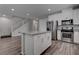 Kitchen island with granite countertop overlooks stainless steel appliances and staircase at 1040 Via Panfilo Ave, Henderson, NV 89011