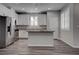 Contemporary kitchen features white cabinetry, gray wood flooring, and a kitchen island at 1040 Via Panfilo Ave, Henderson, NV 89011