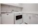 Functional laundry room equipped with a washer, dryer, and ample storage space at 1040 Via Panfilo Ave, Henderson, NV 89011