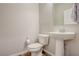 Clean powder room with white fixtures, hardwood floors and a pedestal sink at 1040 Via Panfilo Ave, Henderson, NV 89011