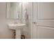 Clean powder room with white fixtures, hardwood floors, a pedestal sink and a towel rack at 1040 Via Panfilo Ave, Henderson, NV 89011