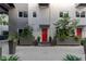 Welcoming entrance with red door, lush landscaping, and modern planters at 11441 Allerton Park Dr # 217, Las Vegas, NV 89135