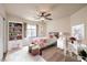 Bright staged bedroom with ceiling fan, decorated bookcase, and desk at 1332 Cedar Berry Ct, Henderson, NV 89012