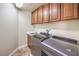 Bright laundry room with washer, dryer, sink, and cabinet storage at 1332 Cedar Berry Ct, Henderson, NV 89012