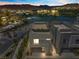 Dusk view of modern exterior with a lake view featuring stucco siding and a two-car garage at 14 Heron Harbour Dr, Henderson, NV 89011