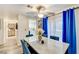 Dining area with a sleek marble table, comfortable blue chairs, and modern ceiling fan at 1509 Linnbaker Ln # 203, Las Vegas, NV 89110