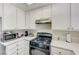 Bright kitchen with ample counter space, white cabinets, and modern black appliances at 1509 Linnbaker Ln # 203, Las Vegas, NV 89110