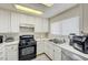 Well-lit kitchen features white cabinets, a black gas range, and a stainless steel dishwasher at 1509 Linnbaker Ln # 203, Las Vegas, NV 89110