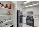 Cozy kitchen with white cabinets, black appliances, and a pantry stocked with glassware at 1509 Linnbaker Ln # 203, Las Vegas, NV 89110