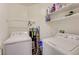 Clean laundry room with a side-by-side washer and dryer and overhead shelving at 1509 Linnbaker Ln # 203, Las Vegas, NV 89110