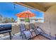 Outdoor patio area with seating, an orange umbrella, and a grill for entertaining at 1509 Linnbaker Ln # 203, Las Vegas, NV 89110