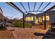 Landscaped backyard with a manicured lawn, a brick pathway, and a covered outdoor seating area at 1544 Karst Pond Ave, North Las Vegas, NV 89084