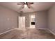 Carpeted bedroom includes ceiling fan, neutral walls, and ensuite bathroom at 1544 Karst Pond Ave, North Las Vegas, NV 89084