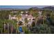 Expansive estate featuring a red tile roof, balcony, pool, and lush landscaping with mature palm trees at 2041 Troon Dr, Henderson, NV 89074