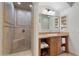 Bathroom featuring a tile shower with built-in bench and vanity with cabinet storage at 21 Via Visione # 201, Henderson, NV 89011