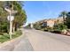 Gated community entrance with manicured landscaping, mature trees, and street sign at 21 Via Visione # 201, Henderson, NV 89011