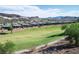 Scenic view of the green golf course and the community homes set against a backdrop of desert mountains at 21 Via Visione # 201, Henderson, NV 89011
