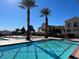Resort-style pool area featuring multiple pools, lounging areas, and palm trees against a bright blue sky at 21 Via Visione # 201, Henderson, NV 89011