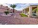 Spacious backyard with covered patio, desert landscaping, and a view of the elevated hillside at 2125 Desert Woods Dr, Henderson, NV 89012