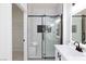 Bathroom showcasing a glass walk-in shower with a black shower head and marble tile at 2125 Desert Woods Dr, Henderson, NV 89012