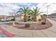 Well-manicured front yard featuring palm trees, stone mulch, lush shrubs, and healthy green grass at 2125 Desert Woods Dr, Henderson, NV 89012