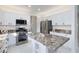 Well-equipped kitchen featuring granite countertops, stainless steel appliances, and white cabinetry at 2125 Desert Woods Dr, Henderson, NV 89012