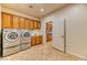 Well-equipped laundry room with modern washer and dryer, tile flooring, and ample storage at 2253 Laurel Heights Ln, Henderson, NV 89052