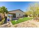 Charming backyard with green lawn, desert landscaping, and a cozy patio area perfect for outdoor living at 24 Cliffwater St, Henderson, NV 89011