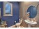 Stylish powder room with blue accent wall, tiled wall, modern fixtures, and plantation shutters at 24 Cliffwater St, Henderson, NV 89011