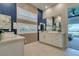 Stylish bathroom featuring dual vanities, modern lighting, and a view of the outside from the bedroom at 24 Cliffwater St, Henderson, NV 89011