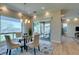 Bright dining area with glass table, cushioned chairs, chandelier, and view of the outdoor patio at 24 Cliffwater St, Henderson, NV 89011