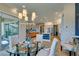 Open-concept dining area with modern chandelier, leading to a living room and a white kitchen at 24 Cliffwater St, Henderson, NV 89011