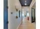 Bright hallway with art and blue accent ceiling leads to an open floor plan with ample natural light and hardwood floors at 24 Cliffwater St, Henderson, NV 89011