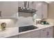 Close up of modern kitchen with stainless steel hood, white subway tile backsplash and light countertops at 24 Cliffwater St, Henderson, NV 89011