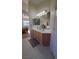 A bathroom with a double sink vanity, oak cabinets, large mirrors, and neutral finishes, offering a clean and bright space at 281 Deerleap Cir, Henderson, NV 89052