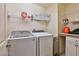 A well-equipped laundry room with modern washer/dryer, shelving and decorative signage at 2832 Aragon Terrace Way, Henderson, NV 89044