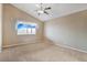 A spacious carpeted bedroom with a ceiling fan and window allowing natural light at 3208 Paragon Pointe St, Las Vegas, NV 89129