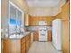 A bright kitchen features oak cabinets, white appliances and a tile backsplash at 3208 Paragon Pointe St, Las Vegas, NV 89129