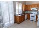 Bright kitchen featuring granite counters, wooden cabinets and white appliances, with view to the backyard at 3208 Paragon Pointe St, Las Vegas, NV 89129