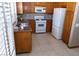 Kitchen features wooden cabinets, tile backsplash, white appliances, and granite countertops at 3208 Paragon Pointe St, Las Vegas, NV 89129