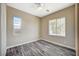 Bright bedroom with wood-look floors, two windows, a ceiling fan, and neutral walls at 3356 Dalmore St, Henderson, NV 89044